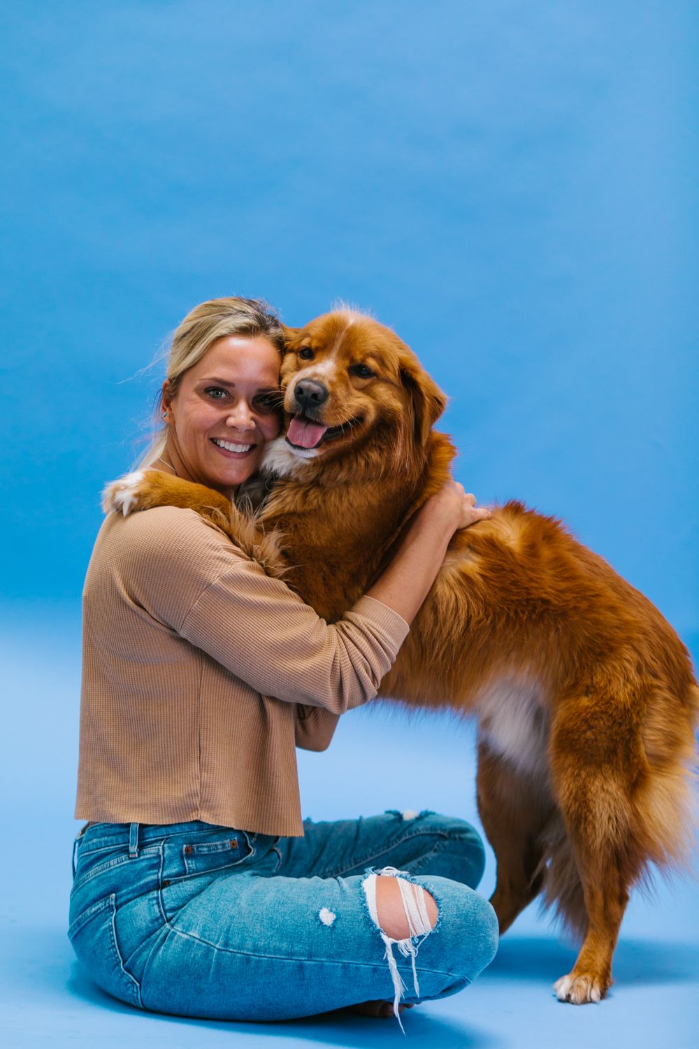 Mujer sonriendo junto a su perro